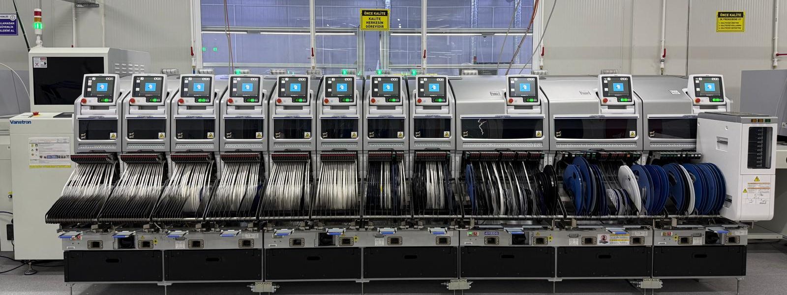 Besleyicileri yüklenmiş SMT dizgi makinelerinden oluşan üretim hattı